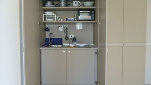 A compact kitchenette with a microwave, kettle, and small sink. - PietraBianca Marzamemi (Syracuse)