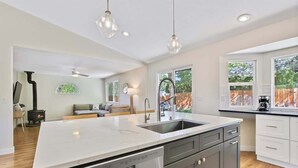 A modern kitchen with a large island, stainless steel appliances, and pendant lighting.