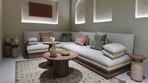 A modern living room with a sofa, a coffee table, and decorative vases. - NOZOL ALRAYAHEEN  (Khor Fakkan)