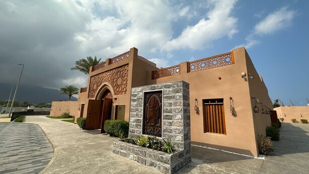 A building with a traditional design, featuring a stone entrance and decorative metalwork. - NOZOL ALRAYAHEEN  (Khor Fakkan)