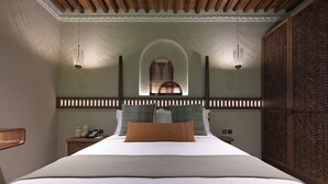 A bedroom with a bed, bedside tables, a nightstand, and a decorative wall panel. - NOZOL ALRAYAHEEN  (Khor Fakkan)