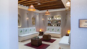 A modern living room with white sofas, wooden coffee tables, and decorative lighting. - NOZOL ALRAYAHEEN  (Khor Fakkan)