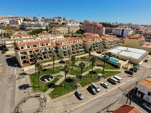 A hotel with multiple floors, a swimming pool, and a parking area. - Sunset Apartment by ACasaDasCasas (Ericeira)