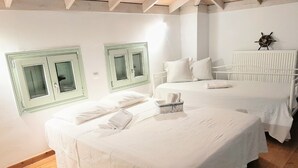 Ein Hotelzimmer mit zwei Betten, Holzboden und einer Schiffslenken-Dekoration an der Wand.