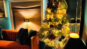 A cozy living room with a Christmas tree, a sofa, a lamp, and a fireplace. - 2 Bed Cosy Cottage, Bawtry - High End Accommodation (Bawtry)