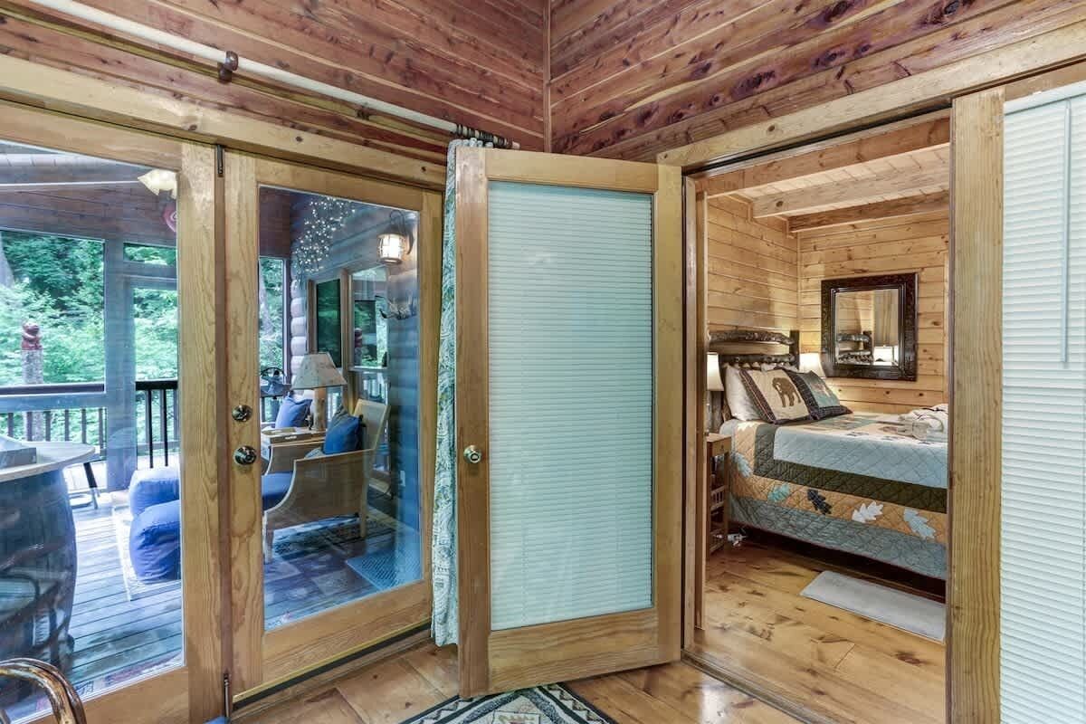 A wooden cabin interior with a glass door leading to a deck area.