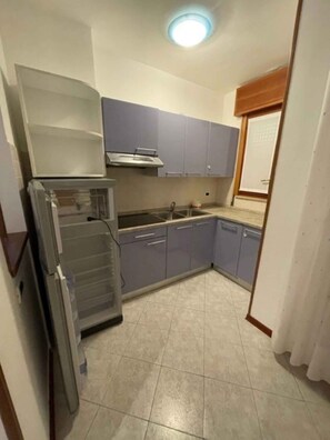 A compact kitchen with a refrigerator, stove, and sink.
