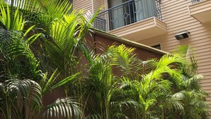 A multi-story building with balconies, potted plants, and a tiled ground. - UDS Villa - Next to VFS, Walking to Connaught Place (New Delhi)