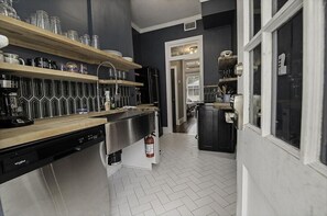 A kitchen with wooden shelves, a dishwasher, and a refrigerator.