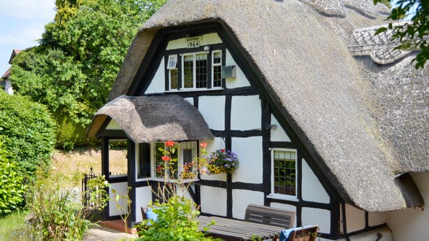A traditional thatched-roof house with a sign indicating restoration in 1964. - Corner Thatch - Worcestershire, a charming cottage sleeps 4 guests in 2 bedrooms (Abbots Morton)