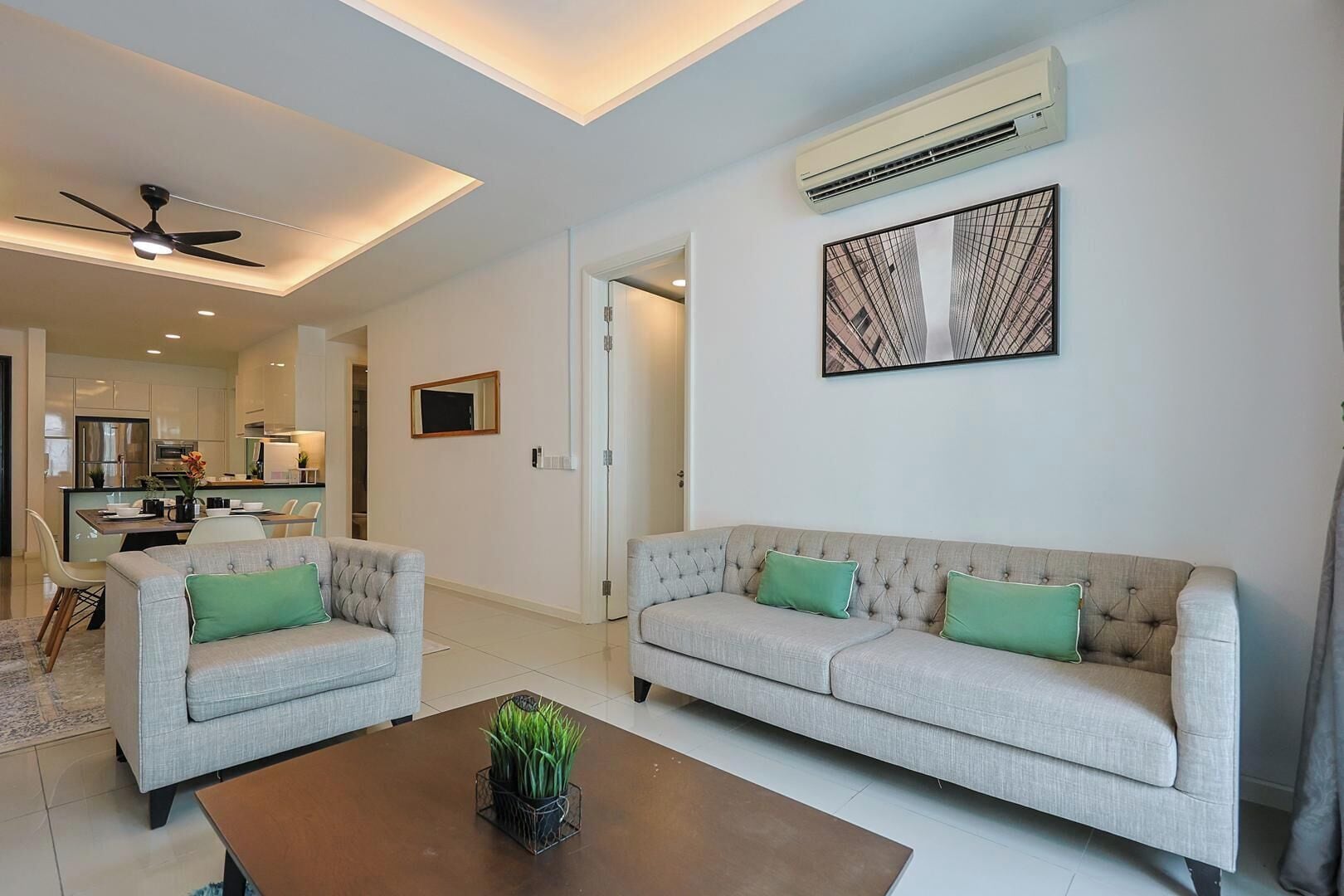 Una sala de estar moderna con un conjunto de sofás, una mesa de centro y un ventilador de techo.