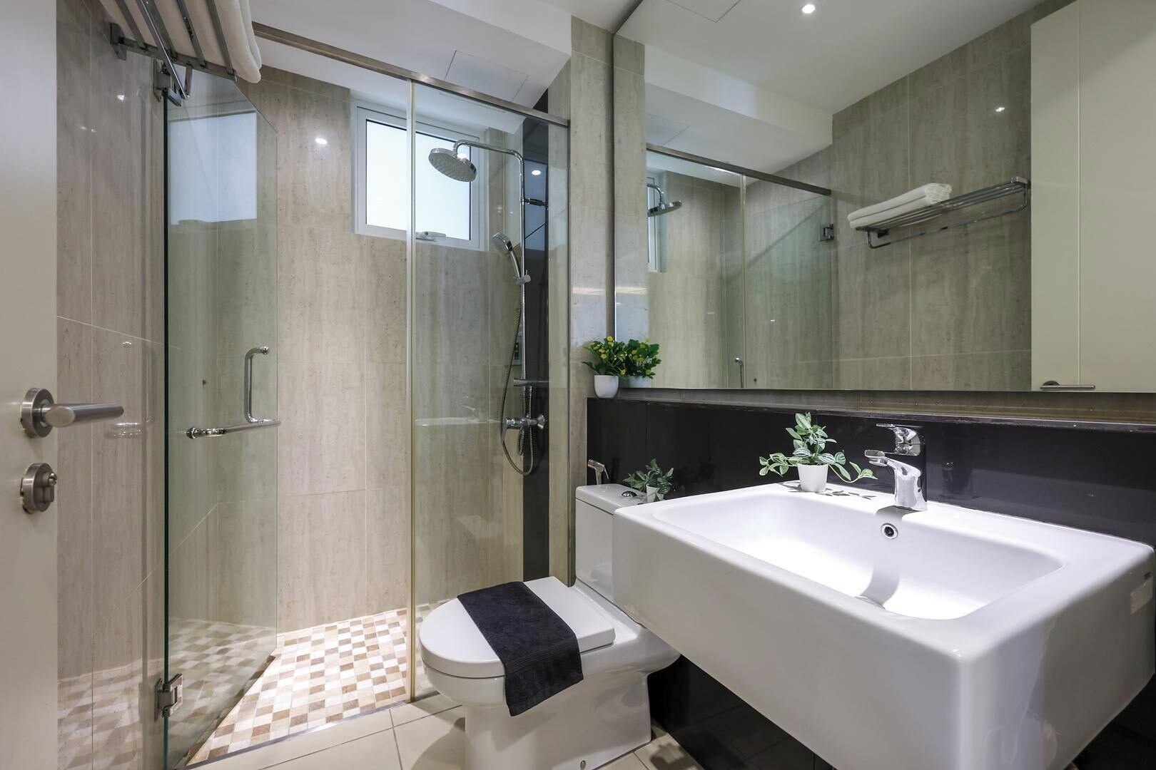 A modern bathroom with a glass-enclosed shower, a white bathtub, and a large mirror.