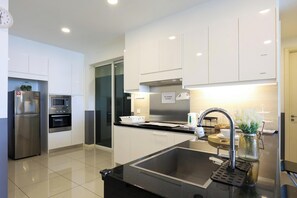 A modern kitchen with stainless steel appliances, a black sink, and a 'NO COOKING ALLOWED' sign. - The Shore Residence Melaka By I Housing (Malacca City)