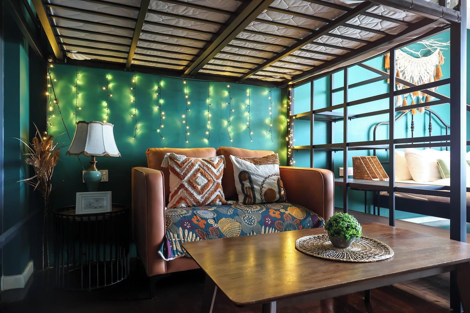A cozy room with a sofa, a table, and a window with a view.