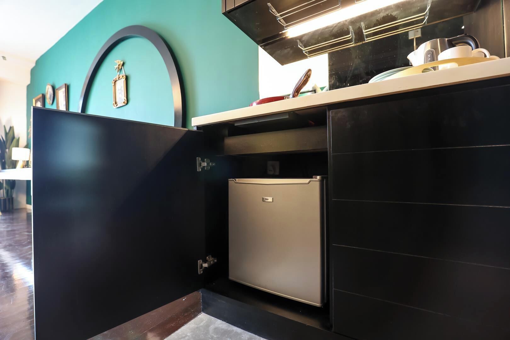 A compact kitchen with a built-in refrigerator, a countertop, and a wall-mounted oven.