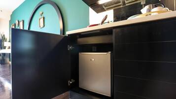 A compact kitchen with a built-in refrigerator, a countertop, and a wall-mounted oven.