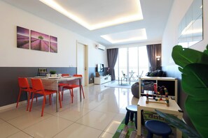 A modern living room with a dining area, a TV, and a large window. - The Shore Residence Melaka By I Housing (Malacca City)