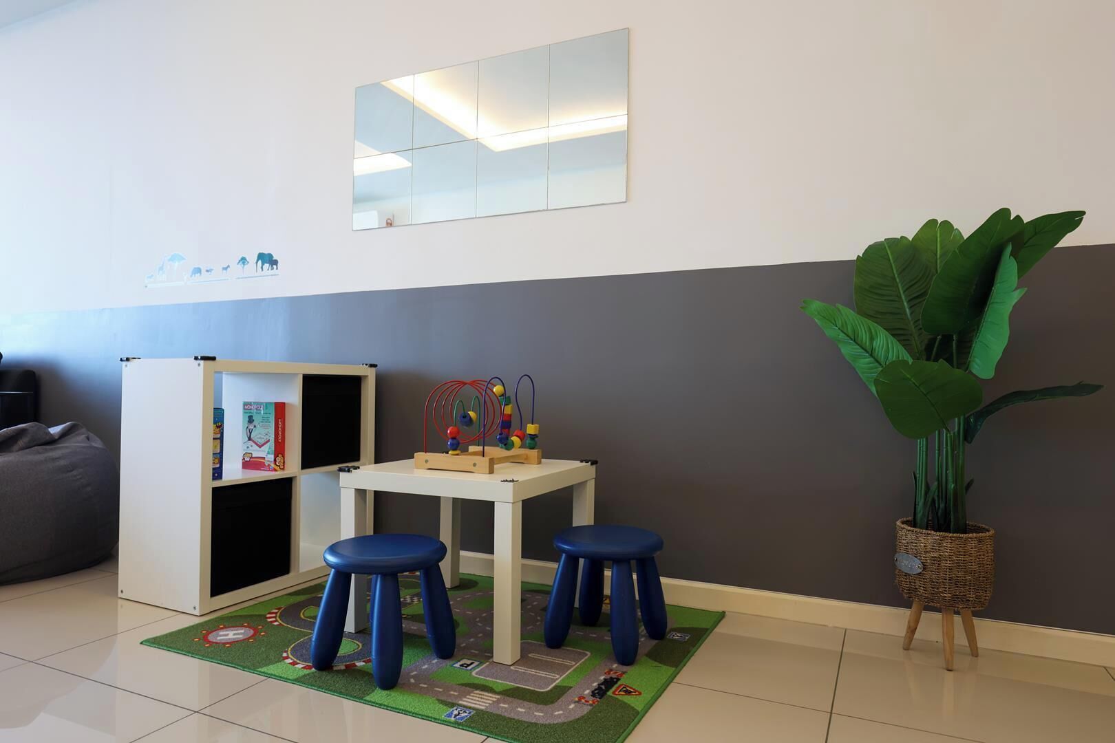 Un espace de jeux pour enfants avec une table, des tabourets et des jouets.