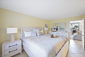 Quarto com cama, mesas de cabeceira, cômoda e televisão.