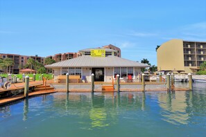 A waterfront building with a signboard listing amenities like gas, bait, tackle, and refreshments. - Riverfront condo in Olde Marco | Pools/Tennis (Marco Island)