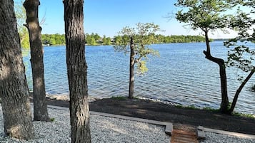 A gravel path leading to a dock over water, surrounded by trees.