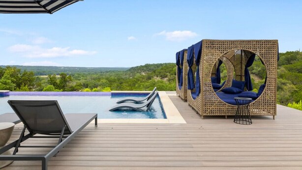 Zona junto a la piscina con piscina, sillas de descanso y una hamaca con vistas al paisaje.