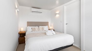 A bedroom with a bed, bedside tables, an air conditioning unit, and a door. - RDR301 - PH in Golden Banús with Sea and Mountain views (Marbella)