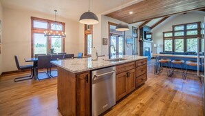 A spacious kitchen with wooden cabinets, a granite countertop, and a built-in dishwasher. - Family Getaway with Access to Exclusive Golf (Sunriver)