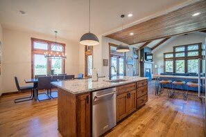 A spacious kitchen with wooden cabinets, a granite countertop, and a built-in dishwasher. - Family Getaway with Access to Exclusive Golf (Sunriver)