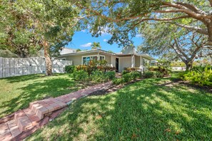 Traditional home with a front porch, garage, and white picket fence.