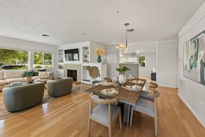Un espace repas moderne avec une table en bois, dressée pour six personnes, entourée de chaises en bois.