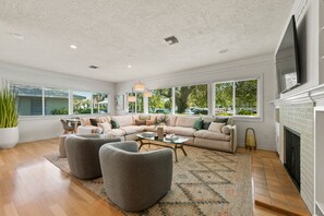 Relax in this inviting living room with a large sofa, armchairs, and a fireplace.