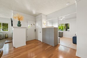 Relax in this spacious room with a clear view of the adjacent kitchen area, featuring modern appliances and an oven.