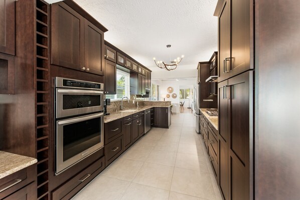 Enjoy cooking in this well-equipped kitchen with a double oven, refrigerator, and central island.