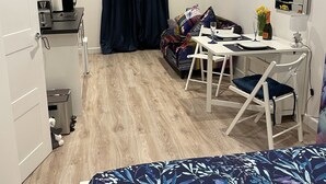 A compact hotel room with a bed, a small kitchenette, a dining area, and a bathroom. - Studio Annie is the most relaxing place to stay  with free off road parking (Worthing)