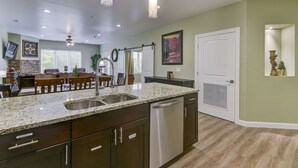 Eine moderne Küche mit Granit-Arbeitsplatten, Edelstahlgeräten und dunklen Holzschränken.