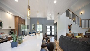 Een moderne keuken met een marmeren eiland, houten keukenkastjes en een inbouwoven.
