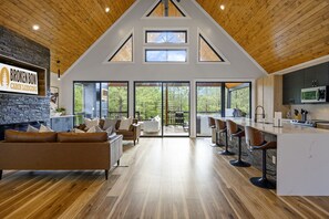 Experience the comfort of Broken Bow cabin's open-plan living space with a modern kitchen, dining area, and cozy seating area.