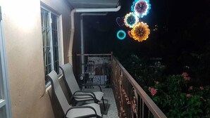 Ein Balkon mit Stühlen, einem Tisch und Geländer.