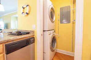 A laundry room with a washing machine, dryer, and a life preserver on the wall.