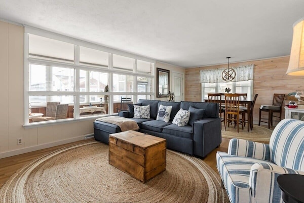 Open living room and fully-equipped kitchen, with dining room table, smart TV, and sleeper sofa.