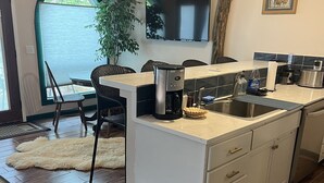 Eine moderne Küche mit integrierter Kochinsel, einer Kaffeemaschine und einem Spülbecken.