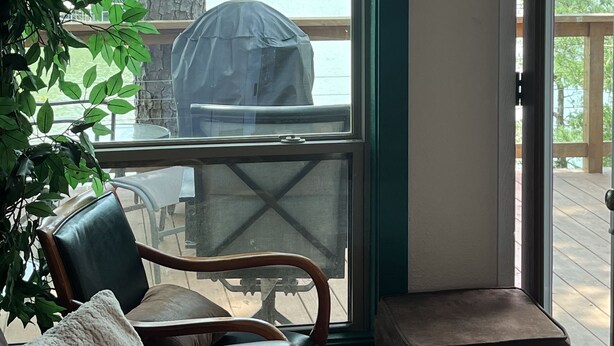 Ein Zimmer mit Seeblick, einer überdachten Grillgelegenheit und einem Essbereich mit Stühlen und Tisch.