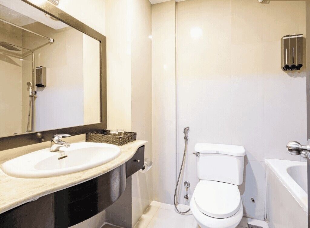 A modern bathroom with a white sink, a toilet, and a shower.
