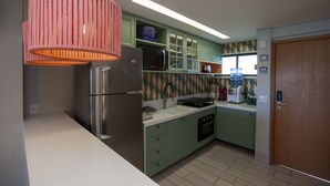 Una cucina moderna con frigorifero, forno a microonde, lavello e pensili.