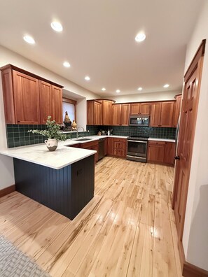 Una cocina moderna con armarios de madera, una isla central y un horno empotrado.