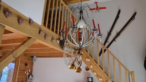 A wooden staircase with a chandelier and ski equipment on the wall. - Appartement Plein Sud (Les Deux Alpes)