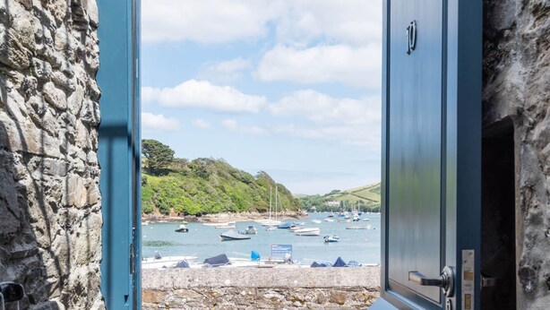 A door with a view of a harbor, stone walls, and a clear sky. - The Old Lobster Pot -  a beautiful, luxury waterfront cottage in the centre of Salome (Salcombe)