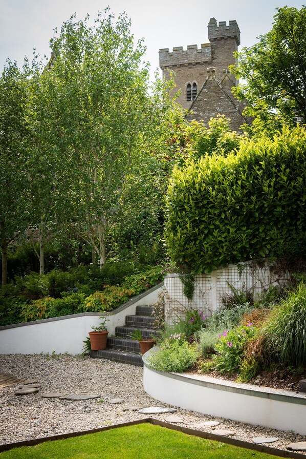 Un jardí amb una escala de pedra que condueix a un edifici semblant a un castell.