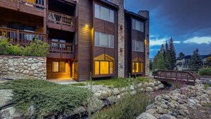 A multi-story building with a stone facade, wooden balconies, and a stone pathway leading to the entrance. - Lift View Place | Steps to Lift | Walk to Main St! (Breckenridge)